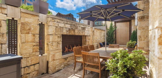 Private outdoor patio with fireplace and custom water feature at 6150 Sherry Lane.